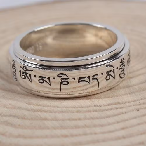 Nhẫn bạc khắc thần chú Om mani Padme Hum. Câu thần chú tiếng Phạn này được xem là thần chú cầu Quan Thế Âm Bồ Tát mang lại bình an cho con người.