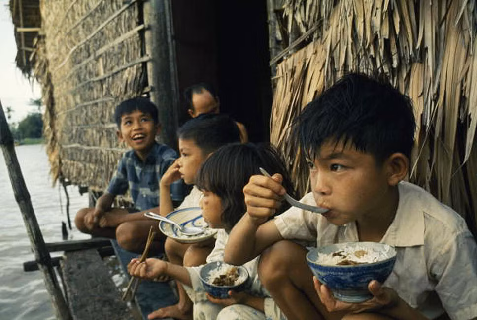 Trẻ em ăn trưa trên một ngôi nhà ven sông ở Cần Thơ.