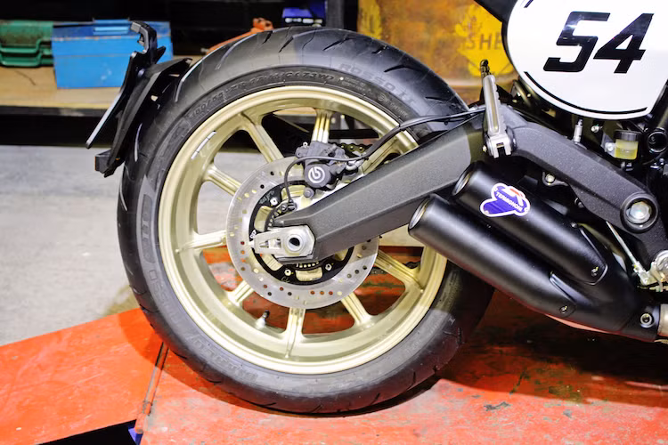 Ở phía sau, Ducati Scrambler Cafe Racer cũng sử dụng vành 17 inch và lốp Pirelli Diablo Rosso II, nhưng có lốp bản rộng tới 180/55/17 để đảm bảo độ bám đường. Cả 2 bánh xe đều sử dụng hệ thống phanh với heo do Brembo sản xuất.