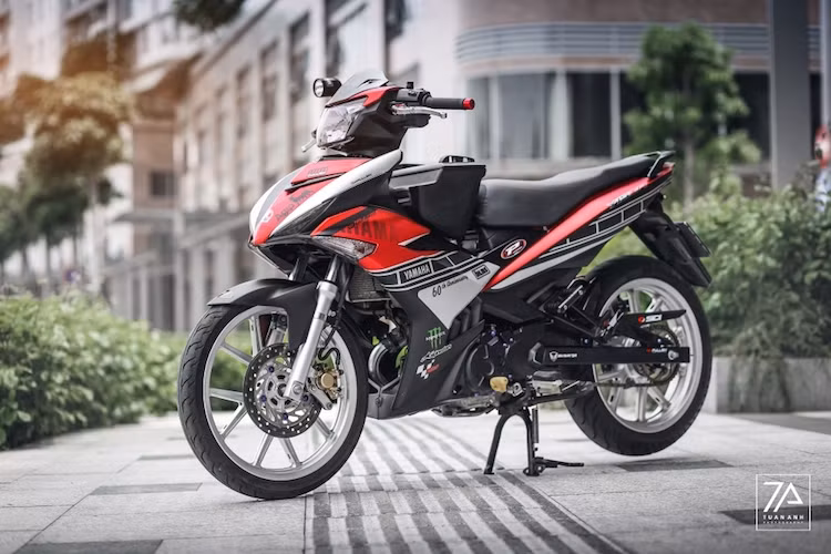 Đi theo phong cách độ kiểng, một biker Sài Gòn đã trang trí lại chiếc xe của mình theo hướng đơn giản nhưng tinh tế. Ngay từ cái nhìn đầu tiên, chiếc xe đã tạo ấn tượng với dàn vỏ được sơn tem đấu theo phong cách Speed Block kỷ niệm 60 năm thành lập Yamaha Motor, nhưng có tông màu đỏ-trắng-đen thay vì vàng-trắng-đen truyền thống.
