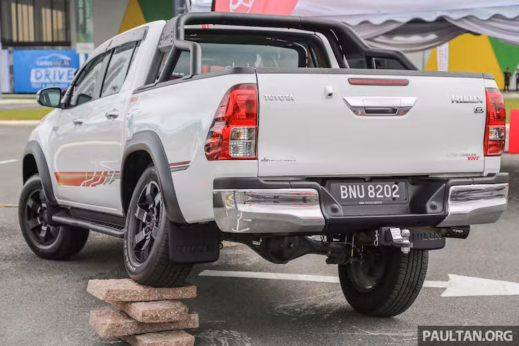 Ở hai bên thân xe, phiên bản Hilux TRD đã có thêm bậc bước chân làm bằng thép không rỉ, được sơn đen mờ mạnh mẽ. "Dàn chân" của xe cũng được nâng cấp với mâm thể thao 6 cánh 18 inch, lốp lớn hơn nằm trong các vòm bánh được ốp nẹp nới rộng. Ở phía sau, Hilux TRD có thêm giằng thép trên thùng sau, chụp ống xả TRD bằng sợi carbon.