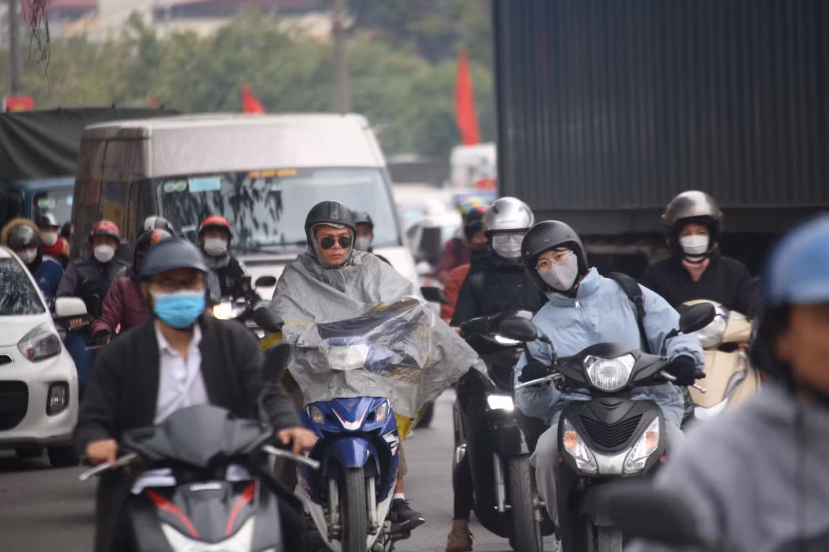 Nhiều người phải mặc áo mưa khi di chuyển quãng đường dài.