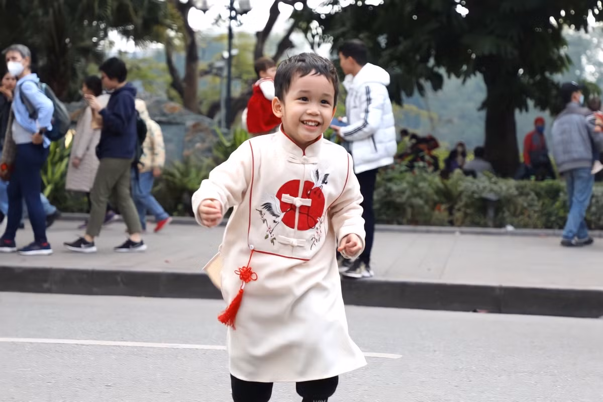 Nhiều em nhỏ được bố mẹ diện bộ đồ Tết để xuống phố du xuân.