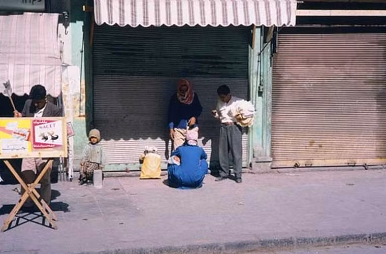 Những người dân Syria đi chợ đang đứng nghỉ bên một cửa hàng đóng cửa. Ảnh OLA