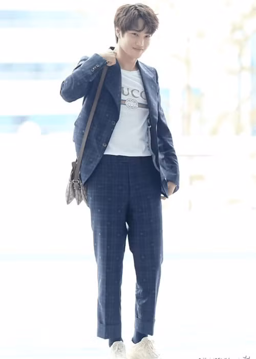 Kai (EXO): Nam giới Hàn Quốc ưa chuộng mặc suit ngay cả trong những hoạt động thường ngày. Tuy nhiên, họ có cách phối đồ khiến bộ tây trang cổ điển trở nên trẻ trung, năng động và thời trang hơn. Kai cũng thuộc nằm lòng các bí kíp phối hợp này khi diện suit cũng áo thun trắng in logo và giày thể thao cá tính.