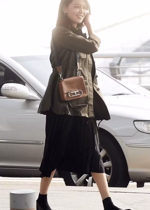 Soo Young (SNSD): Báo Hàn đưa tin chân dài nhóm SNSD luôn được bình chọn là một trong những thần tượng có gu thời trang tốt nhất Kpop. Phong cách của cô thiên về sự nữ tính nhưng vẫn thoải mái, năng động. Áo khoác theo phong cách quân đội màu xanh rêu kết hợp cùng chân váy xếp pli đen dài quá gối là trang phục sân bay mang phong cách khá đặc trưng của Soo Young.