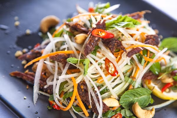 Trong khi đó, gỏi khô bò với đu đủ sợi giòn tan, nước sốt đậm đà là món ăn “gây nghiện” mỗi buổi xế chiều. Ảnh Cookpad