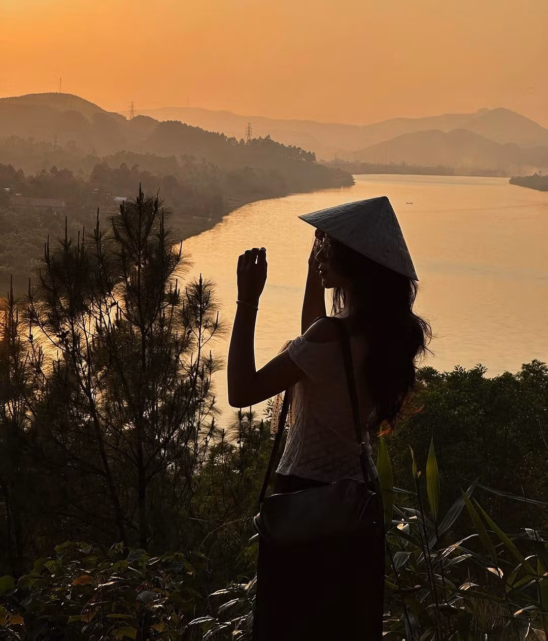 Cách trung tâm thành phố khoảng 7km, Đồi Vọng Cảnh là điểm ngắm nhìn toàn cảnh dòng sông Hương thơ mộng uốn lượn giữa những rừng thông xanh mướt. Khi hoàng hôn buông xuống, nơi đây trở thành phông nền lý tưởng cho những bức ảnh nhuốm màu cổ tích. Dịp lễ 30/4, thời tiết Huế nắng nhẹ, cực kỳ thích hợp để leo đồi, ngắm cảnh và tận hưởng không khí mát lành. Ảnh Thanh.hangg