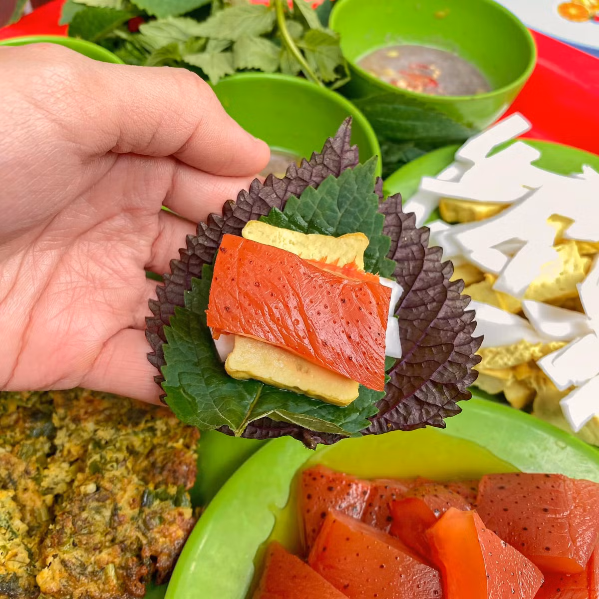 Món sứa đỏ khi ăn thường được bày cùng các nguyên liệu dân dã như đậu phụ mơ chấm nước mắm nhạt, dừa tươi thái sợi, rau kinh giới, tía tô và đặc biệt là mắm tôm đánh bông. Ảnh Internet