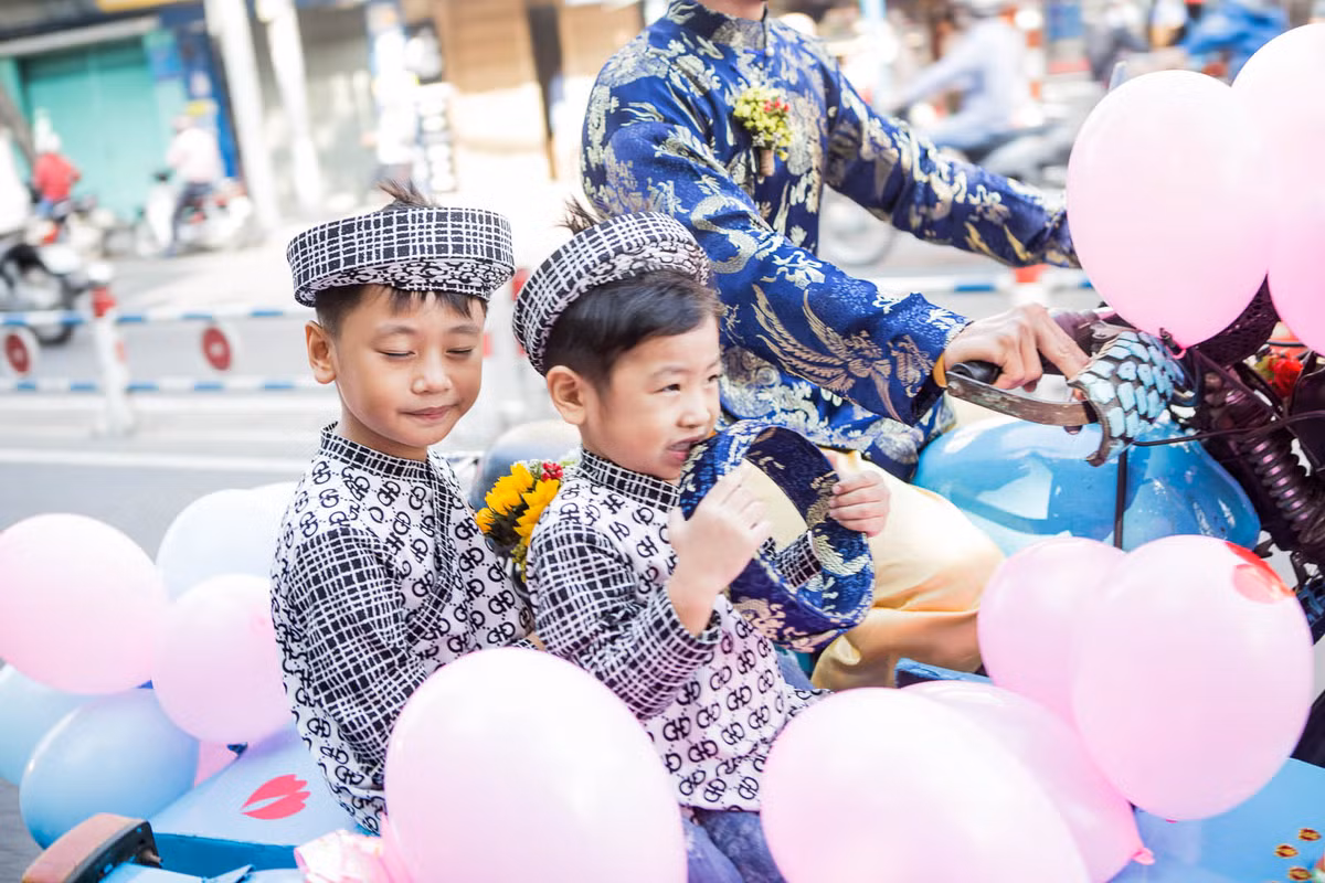 Hai phù rể nhí háo hức kh được du ngoạn đường phố bằng xe hoa.