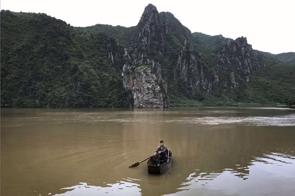 Một người đàn ông chèo thuyền trên hồ nước tại điểm dừng chân tại Sinpyong dọc theo đường cao tốc Bình Nhưỡng-Wonsan vào ngày 22/7. Ảnh: AP.