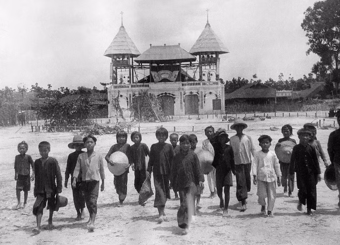 Trẻ em giáo dân đứng trước khu Tòa thánh đầu tiên của đạo Cao Đài ở Tây Ninh. Năm 1947, Tòa thánh mới được khánh thành và trở thành một trong những công trình tôn giáo nổi tiếng nhất Việt Nam.