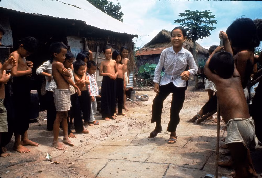 Em Nguyễn Thị Tròn, bị mất chân do hỏa lực từ trực thăng Mỹ, đang chơi đùa cùng bạn bè với chân giả, Tây Ninh năm 1968.