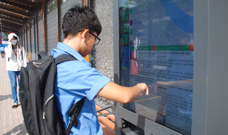 Một hành khách cập nhật thông tin tại trạm xe bus được đánh giá "5 sao" ở Sài Gòn.