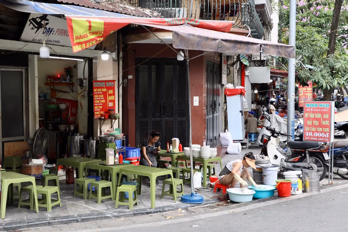 Tại phố Hàng Chiếu, quán ăn ngang nhiên bày bán hết toàn bộ vỉa hè, chiếm phần đường của người đi bộ. Thậm chí nhân viên còn rửa bát ngay trên vỉa hè trông rất nhếch nhác, mất mỹ quan đô thị.
