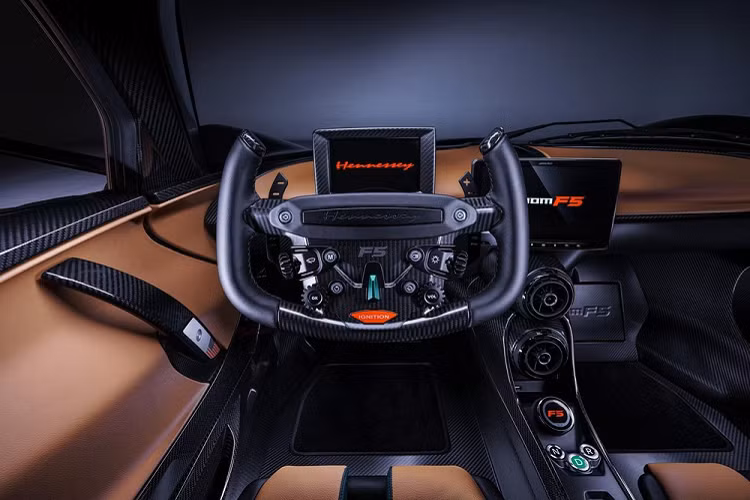 Bên trong Hennessey Venom F5 2021, có rất nhiều khu vực được bọc bằng sợi carbon, điểm xuyết thêm chất liệu da cho thêm mời gọi. Vô lăng bọc sợi carbon của xe lấy cảm hứng thiết kế từ máy bay và xe đua Công thức 1. Vô lăng này tích hợp các nút chỉnh đèn, cần gạt nước, đèn xi-nhan và đi kèm cả lẫy chuyển số. Trong khi đó, trên cụm điều khiển trung tâm với thiết kế thanh mảnh sẽ có nút chọn chế độ lái và nút bấm chuyển số.