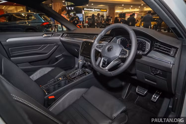 Bên trong, Volkswagen Passat R-Line có vô lăng đáy phẳng thiết kế dày hơn, có tích hợp lẫy chuyển số. Chân ga và chân phanh làm nhôm. Ghế và bảng taplo bọc da Nappa đen, các chi tiết trang trí họa tiết carbon.