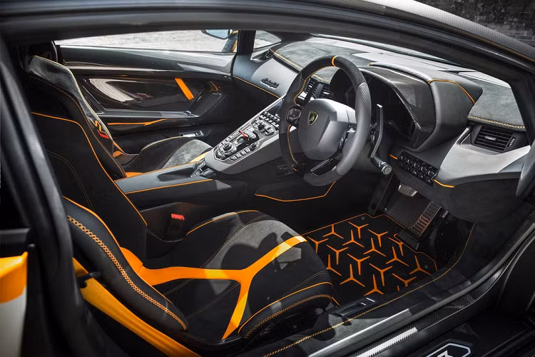 Bên trong cabin, nội thất được thiết kế chủ đạo theo màu Nero Cosmus Black Alcantara. Các điểm nhấn màu cam Arancio Leonis trên ghế, thảm và bảng táp-lô tạo sự tương phản.