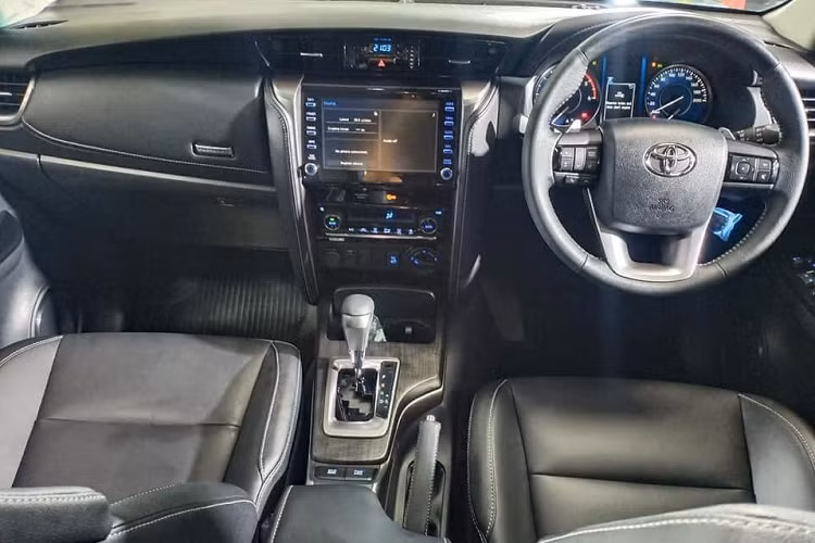 Bên trong nội thất, Toyota Fortuner được trang bị hệ thống kết nối T-Connect, người dùng có thể xem tình trạng xe, hành trình và định vị xe thông qua ứng dụng điện thoại. Màn hình giải trí tương thích Apple CarPlay và Android Auto.