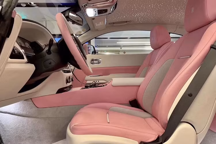 Chưa hết, khác với nhiều chiếc Coupe siêu sang Rolls-Royce Wraith khác trên thế giới có màu sơn hồng đa phần sẽ chọn logo Spirit of Ecstasy bằng bạc hoặc mạ vàng, riêng chiếc Rolls-Royce Wraith này có logo Spirit of Ecstasy dạng trong suốt và sẽ đổi màu khi màn đêm buông xuống.