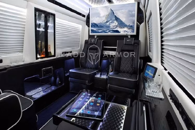 AddAromor cung cấp hai cách trang trí nội thất cho Sprinter, một gồm các ghế màu đen đi kèm đường chỉ khâu tương phản, sàn tối màu, đèn chiếu sáng màu xanh lam trên trần và một chiếc tủ gắn trên tường chứa những chai rượu sâm banh và ly.