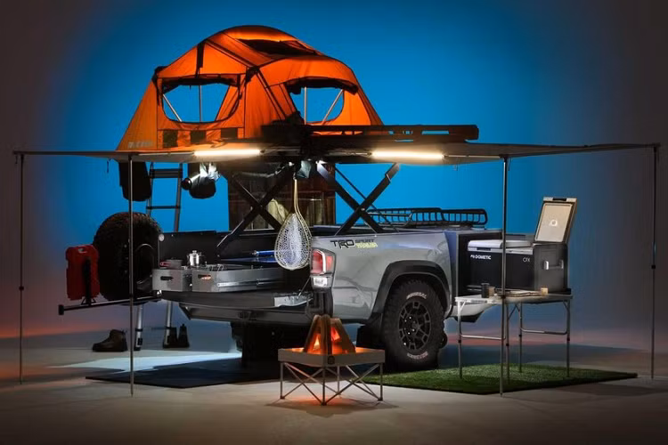 Như những gì được thấy ở đây, TRD Sport cho Toyota Tacoma có hệ thống thang cắt kéo có thể nâng bệ của nó lên cao trên 1 mét khỏi phần thùng. Nó tích hợp một lều trại Yakima cho 4 người với mái hiên và giá đỡ cần câu cá, một bộ tủ lạnh và tủ đông, một vòi tắm hoa sen di động hoàn chỉnh với rèm che và bình nước nóng.