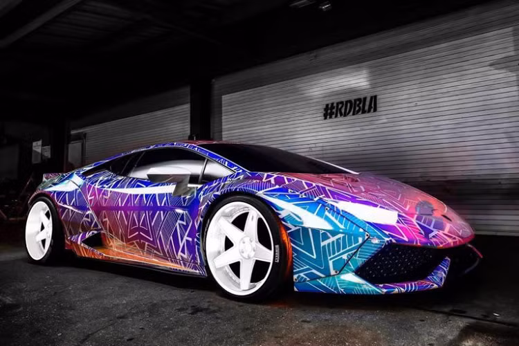 Xuất hiện trong bài viết là chiếc Lamborghini Huracan LP610-4 độ Liberty Walk của nam ca sĩ nổi tiếng. Nếu bạn cho rằng một chiếc Huracan được nâng cấp với gói độ widebody đến từ Liberty Walk đã là quá đủ thì Chris Brown lại không nghĩ vậy, để tạo dấu ấn riêng, toàn bộ ngoại thất của chiếc Huracan này được khoác lên một lớp decal phản quang đặc biệt và có khả năng đổi màu.
