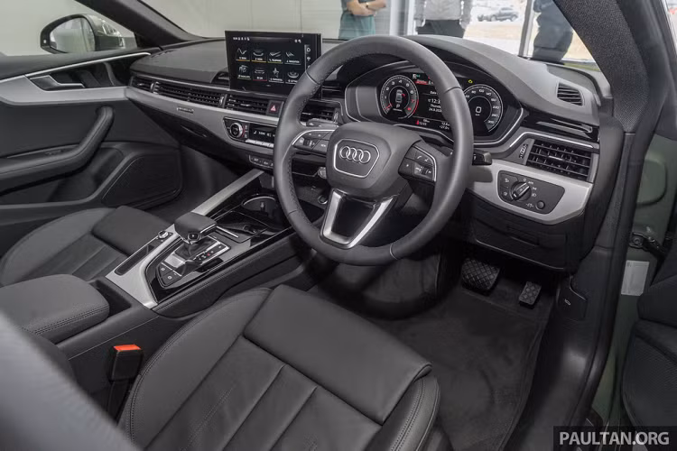 Bên trong, Audi A5 Sportback facelift không thay đổi quá nhiều, cách bố trí vẫn tương tự thế hệ cũ. Vô lăng có thiết kế mới, màn hình giải trí 10,1 inch lớn hơn trước. Dưới bệ tỳ tay trung tâm là ngăn chứa đồ và khay đựng cốc.