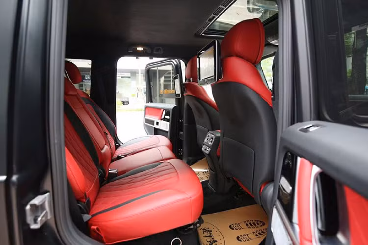 Mercedes-Benz G63 với gói địa Trail Package nổi bật nhờ khoang nội thất kết hợp giữa tông màu đen/đỏ, tạo hình vẫn rất quen thuộc như những biến thể tiêu chuẩn. Mercedes-Benz G63 mới sở hữu vô-lăng dạng D-Cut quen thuộc nhưng điểm nhấn trên bản này đến từ chi tiết ốp carbon và màn hình điện tử phía sau cũng sử dụng vật liệu tương tự. Với chi tiết carbon ở khoang lái, Mercedes-Benz G63 Trail Package càng trở nên cao cấp và sang trọng hơn trên chiếc xe đến từ Đức.