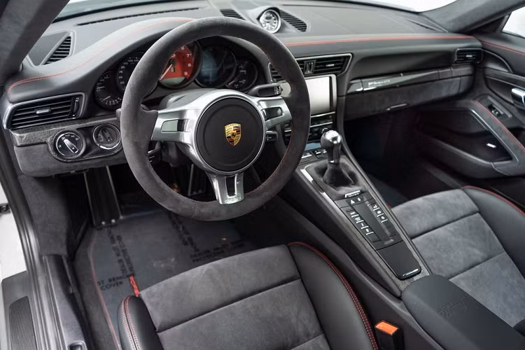 Nội thất của xe gây ấn tượng với bệ cửa ốp carbon cùng gói trang trí GTS. Gói nội thất này bao gồm ghế ngồi thể thao chỉnh điện 18 hướng, đồng hồ tốc độ màu đỏ, vô lăng Sport Design, cần số bọc da Alcantara... Ngoài ra, 911 Carrera GTS Rennsport Reunion còn được trang bị hệ thống âm thanh Bose.