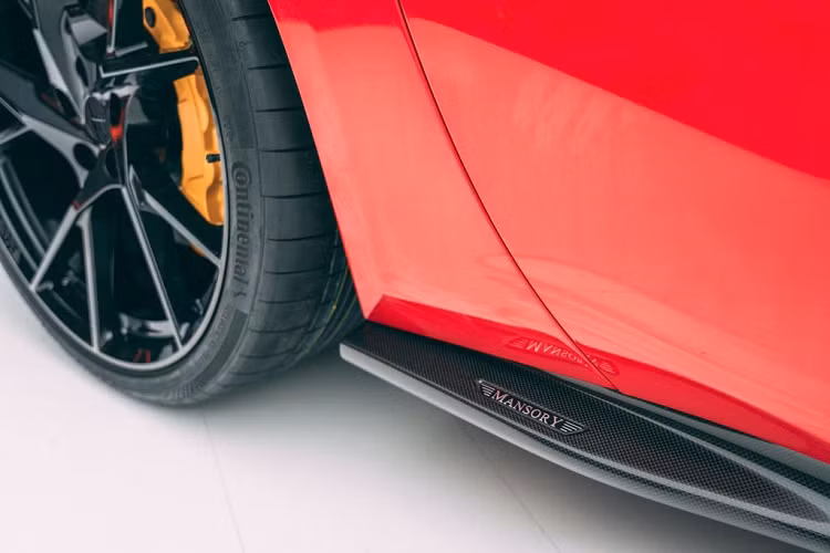 Các thay đổi ngoài ra còn nằm ở bộ mâm mới với nước sơn đen, logo Mansory thay thế cho biểu tượng “Ngựa chồm” trên vòm bánh trước hay cụm đèn hậu với lớp dán đen mờ. Và nếu bạn không ưng ý với kiểu bề mặt sợi carbon bóng như trên hình, Mansory hoàn toàn có thể hoàn thiện những chi tiết này với hiệu ứng mờ hay bề mặt nhám.