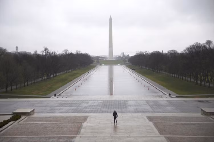 Một người đàn ông đi bộ trong National Mall ở Washington vào ngày 15/3. 