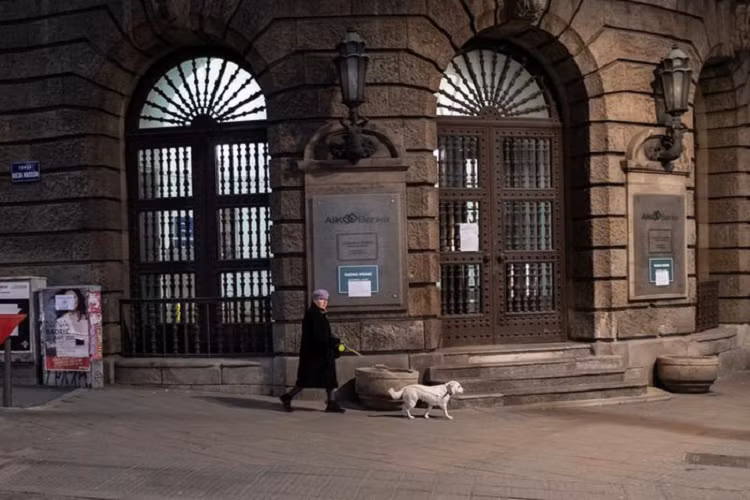 Một người phụ nữ dắt chó đi dạo trong giờ giới nghiêm ở Belgrade, Serbia, ngày 23/3. 