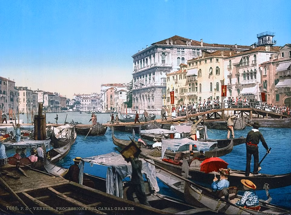Đám rước đi qua một cây cầu bắc qua kênh đào Grand Canal vào một ngày hè.