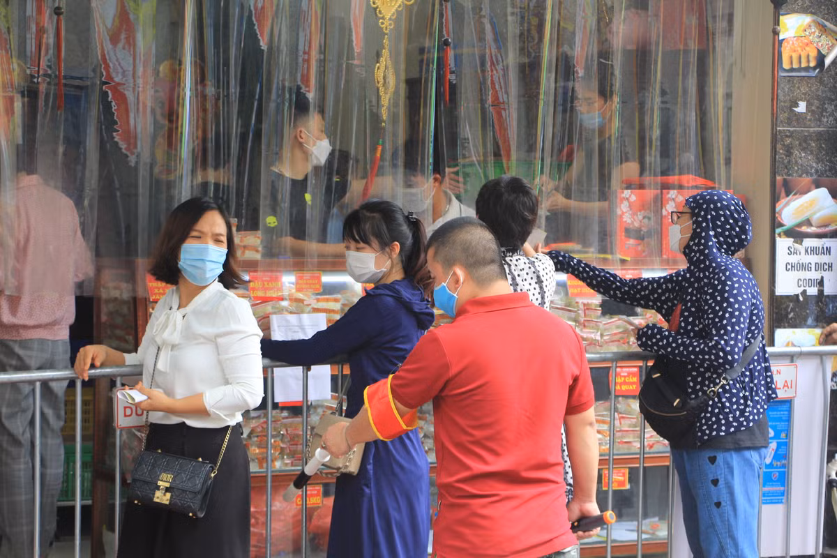 Người của cơ sở sản xuất bánh trung thu này liên tục yêu cầu người dân đứng đúng vị trí, giữ khoảng cách, đảm bảo an toàn phòng chống dịch.