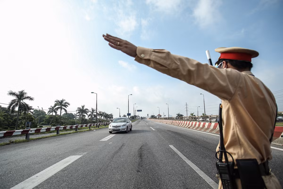 Lực lượng chức năng trực chốt tại cầu Thăng Long ra tín hiệu cho các phương tiện lưu thông dừng lại để kiểm tra giấy đi đường.