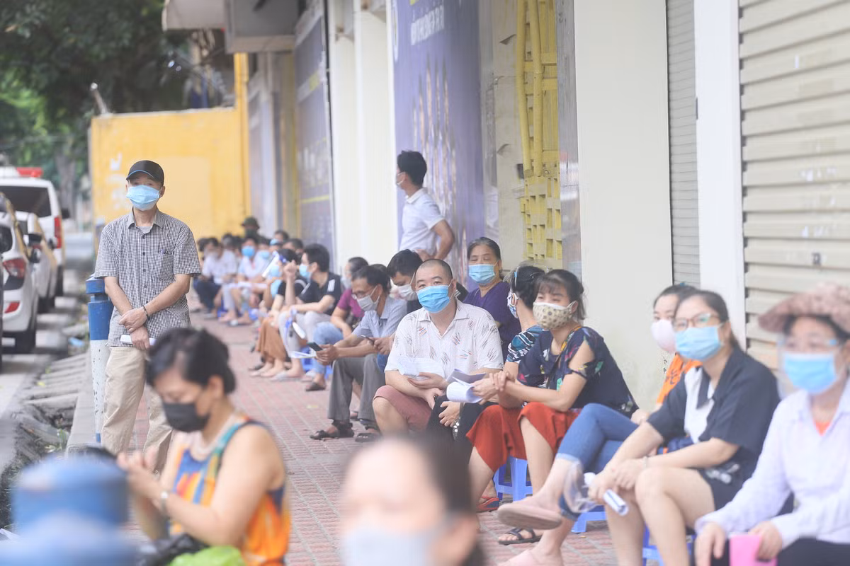 Trước khi đến lượt làm thủ tục tiêm vắc , người dân đến đây được hướng dẫn xếp hàng giãn cách theo đúng quy định phòng chống dịch.