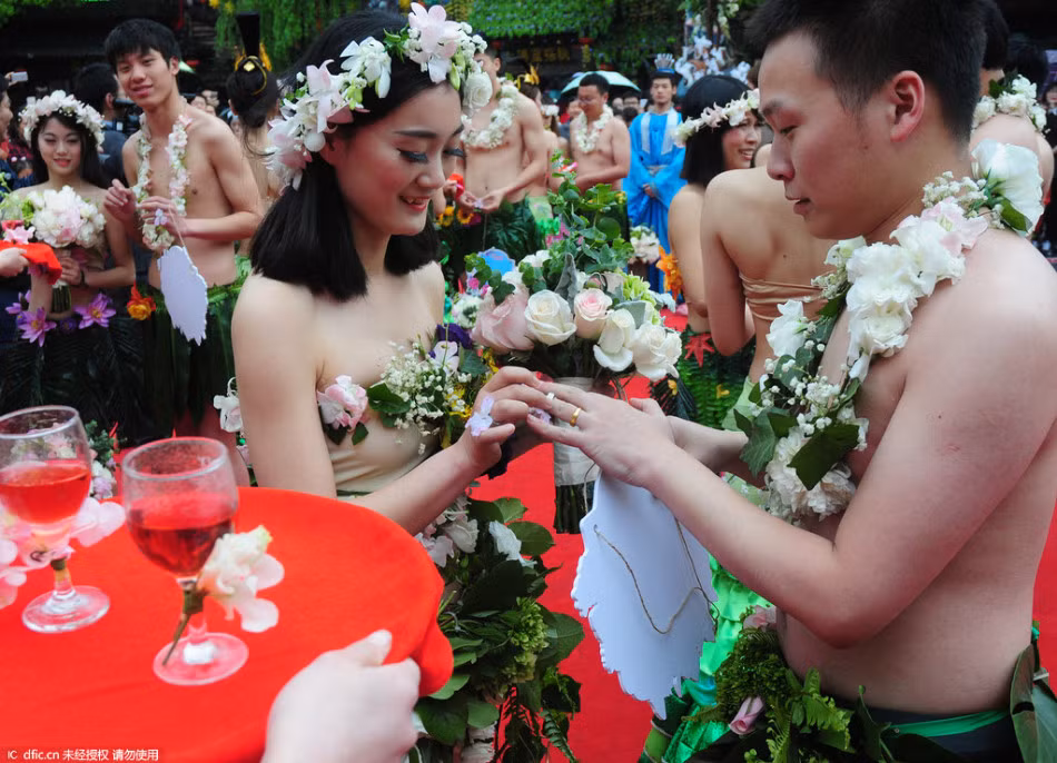 Đôi uyên ương trao nhẫn trong sự chúc mừng của đông đảo mọi người.