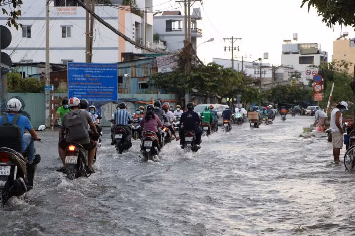 Triều cường dâng cao khiến tuyến đường Trần Xuân Soạn, đoạn dưới cầu Tân Thuận ngập sâu trong biển nước, loạt phương tiện bị chết máy, người dân phải dắt bộ băng qua nước để về nhà.