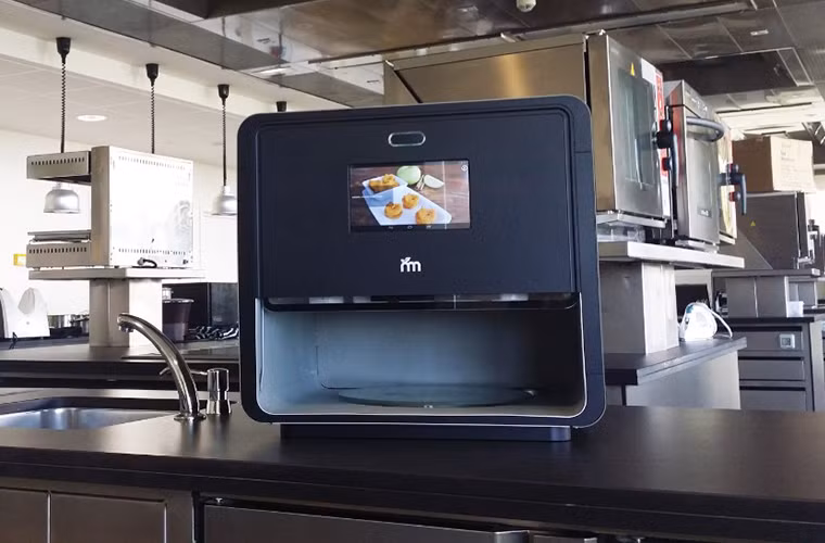 Có tên gọi là "Foodini", chiếc máy in 3D này khác vớicác loại máy in 3D thông thường. Thay vì dùng nhựa để tạo ra sản phẩm, Foodini dùng các nguyên liệu thực phẩm thật để tạo ra các món ăn.