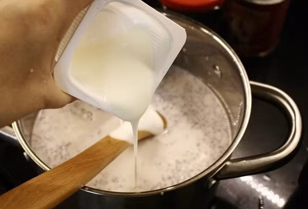 Bước 3: Khi hỗn hợp vừa nấu ở trên nguội khoảng 40 độ C thì cho sữa chua vào và khuấy đều theo một chiều. 
