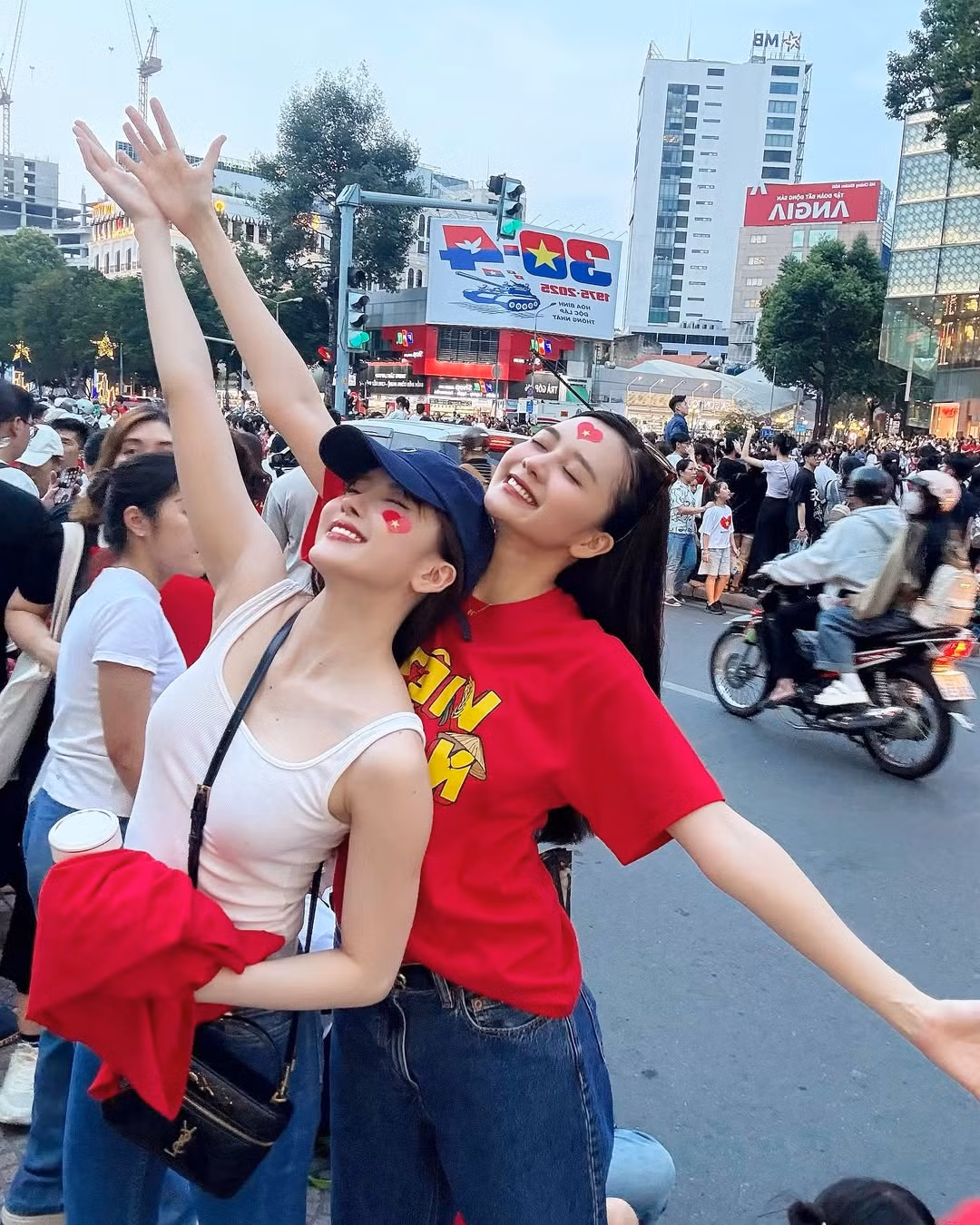 Thiều Bảo Trâm diện chiếc quần jean ôm sát cùng mũ xanh trẻ trung, để lộ vóc dáng thon gọn và làn da trắng mịn, trong khi Thiều Bảo Trang lựa chọn quần ống suông năng động và kính râm tạo điểm nhấn.