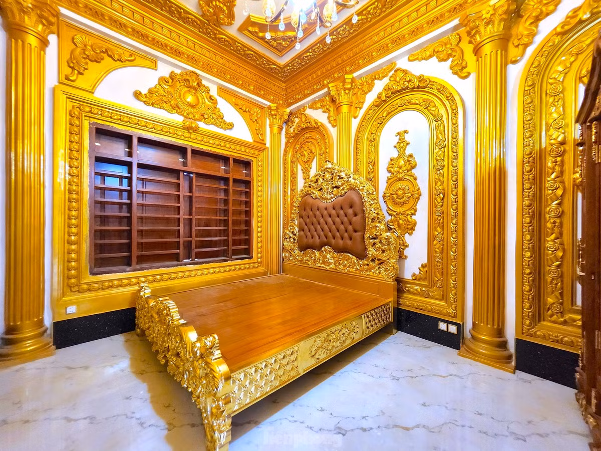 Giường ngủ bọc da, đầu giường chạm trổ họa tiết hoàng gia, thành giường dát vàng lấp lánh. Bao quanh là hệ thống cột trụ cổ điển và vòm mái uốn cong, được trang trí bằng những hoa văn nổi phủ vàng – giống như phòng ngủ trong các cung điện của Versailles hay Buckingham.