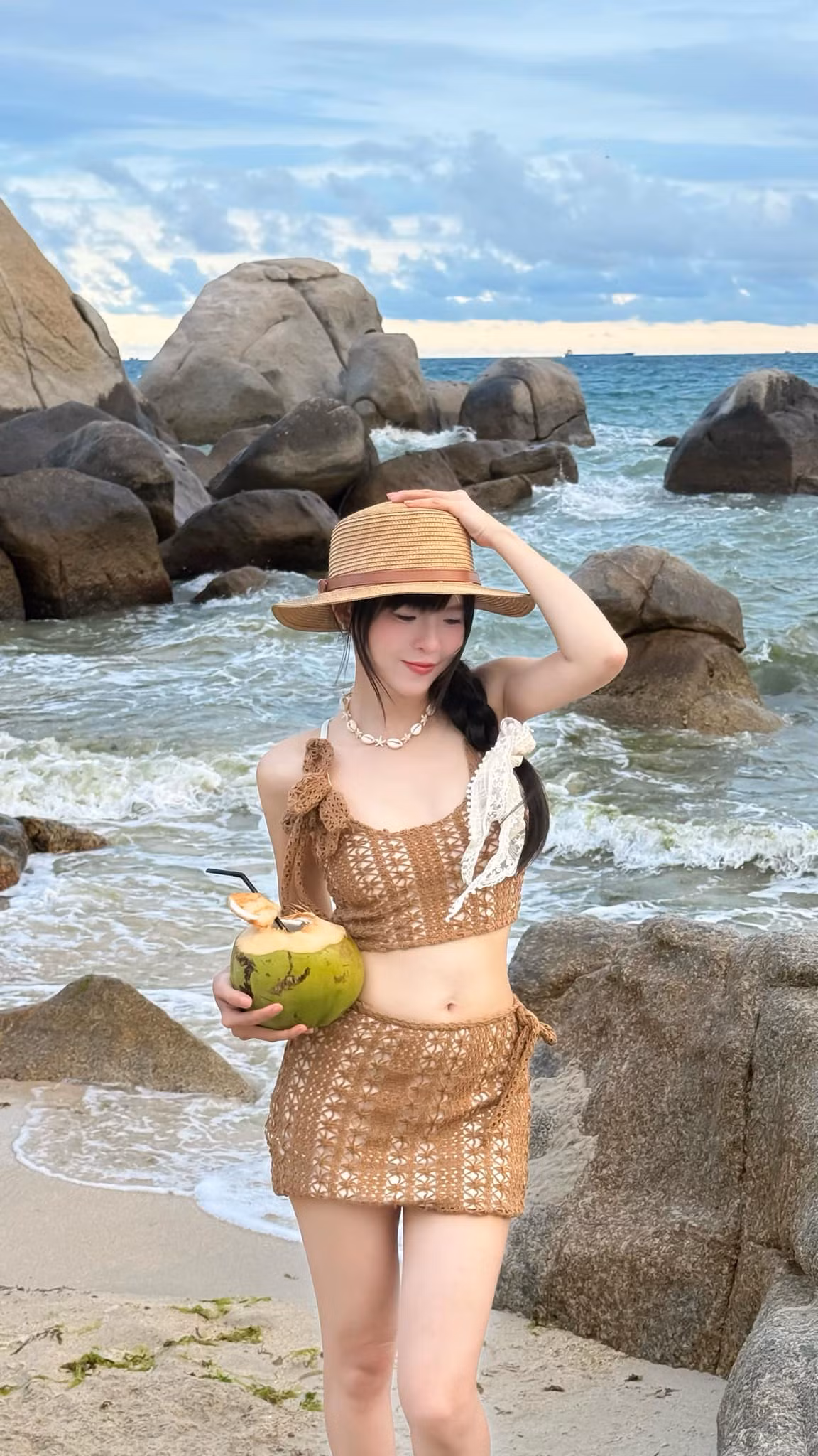 Thúy Kiều chọn cho mình một bộ trang phục crochet (len móc) hai mảnh, gồm áo crop top và chân váy mini đồng bộ. Đây là xu hướng đang “làm mưa làm gió” trong thời trang biển những năm gần đây vừ-a mộc mạc, gần gũi, lại vừa gợi cảm đúng chừng mực.