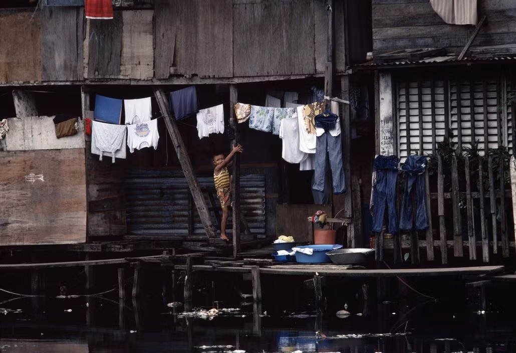 Một khu nhà nằm bên dòng kênh đầy rác rưởi. Ảnh: Peter Marlow/ Magnum Photos.