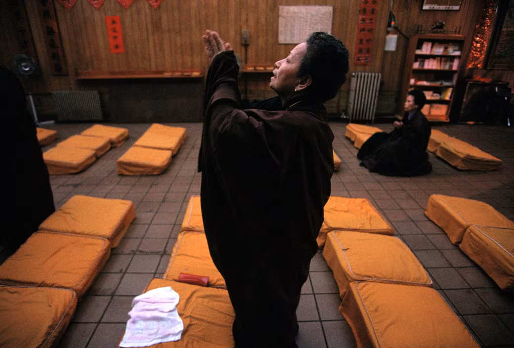 Nữ Phật tử cầu nguyện trong một ngô chùa ở khu Chinatown. Ảnh: Chien-Chi Chang/ Magnum Photos.
