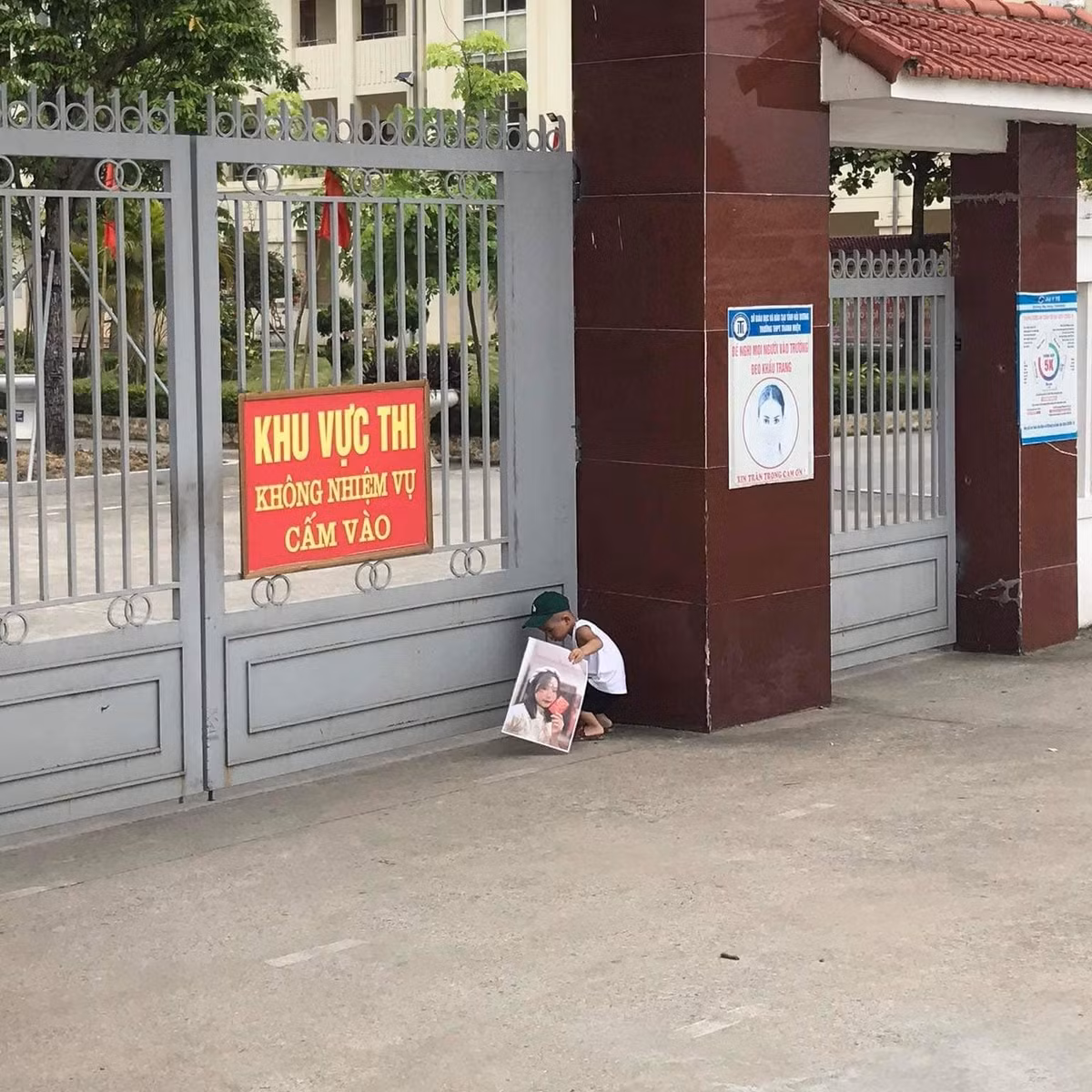 Cậu bé lon ton đứng ngóng chị ở trước cổng trường. Tâm trạng thấp thỏm hệt như một phụ huynh đang chờ mong đứa con của mình hoàn thành bài thi khiến ai nhìn cũng thích thú.
