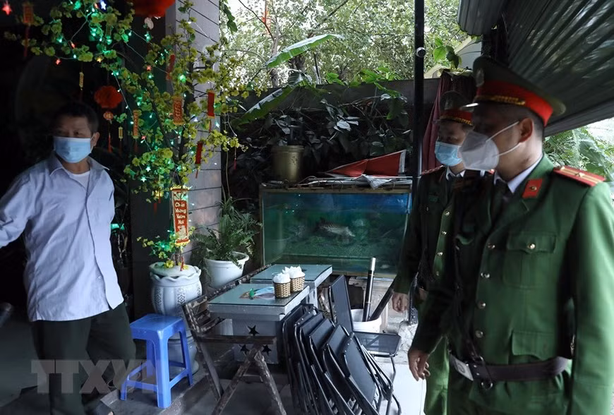 Lực lượng công an nhắc nhở người dân việc thực hiện đóng cửa quán càphê tại khu đô thị Văn Quán, quận Hà Đông. 