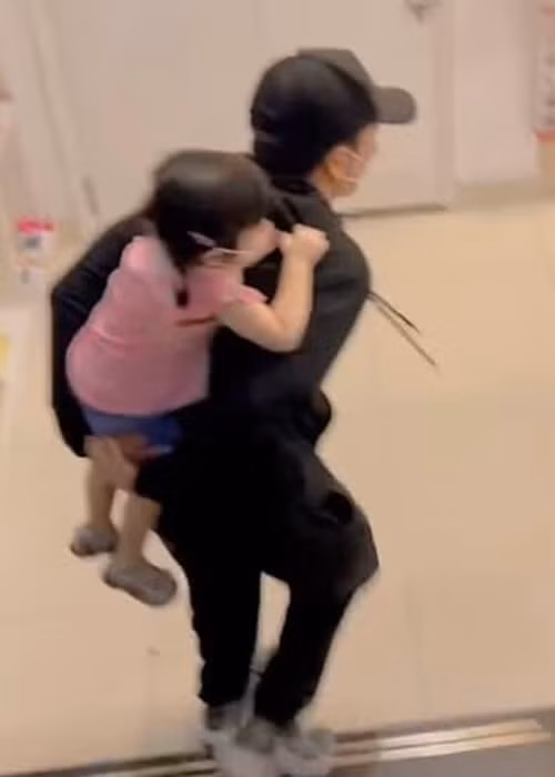 Trường Giang cõng con gái xuống cầu thang khi đi siêu thị. Sau đó, nam diễn viên luôn theo phía sau để dễ quan sát con gái.