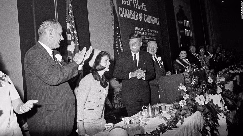 Sau khi máy bay hạ cánh, Tổng thống Kennedy cùng Đệ nhất phu nhân Kennedy và Thống đốc bang Texas John B. Connally Jr. di chuyển bằng chiếc xe limousine với sự chào đón nồng nhiệt của người dân hai bên đường ở Dallas, Texas.